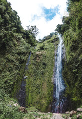 Fototapeta na wymiar Water cascades down the mossy green volcanic cliffs of the San Ramon waterfall on Isla de Ometepe, Nicaragua 