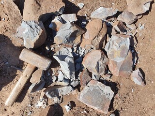 The hammer and chipped stones lie side by side. The hammer was used as an instrument of labor for crushing stones in production.