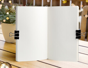 Notebook mockup on a background of wooden table with a bokeh lights