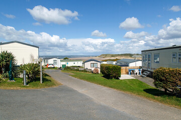 Fototapeta na wymiar Caravan Park - static caravans in Gower with a panoramic format and a blue sky background.
