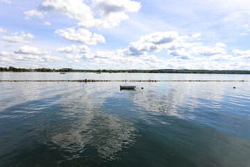 Rowboat on Canandaigua lake.  Morning clouds reflecting on the calm lake in Canandaigua New York