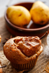 Homemade pear muffin with baked whole pear with cinnamon and sprinkled with powdered sugar close up view