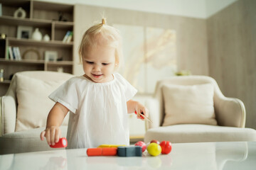 Naklejka premium portrait of a little girl baby kids playing with toys for children. photos for children's companies, products, and ads.