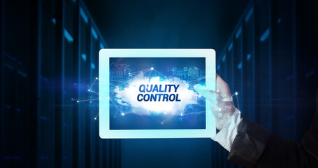 Young business person working on tablet and shows the inscription: QUALITY CONTROL