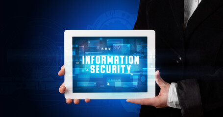 Young business person working on tablet and shows the digital sign: INFORMATION SECURITY