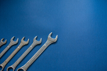 Four wrenches in a corner over a dark blue background