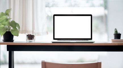 Mockup blank screen laptop on wooden counter table in co-workspace, copy space.