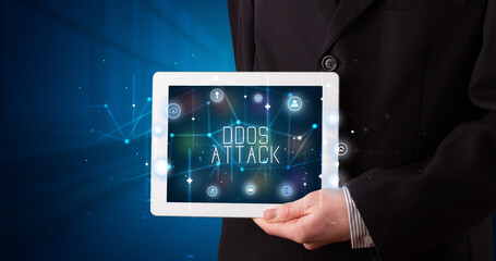 Young business person working on tablet and shows the digital sign: DDOS ATTACK