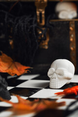Halloween party set up props. White and black sculls with Jack O'Lantern pumpkin. Death symbol. Fear and horror concept. Dia de los Muertos and Halloween. Dark theme with copy space
