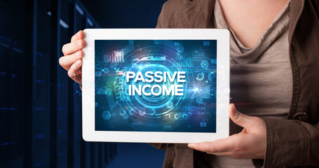 Young business person working on tablet and shows the inscription: PASSIVE INCOME, business concept