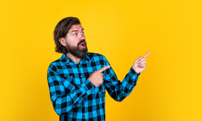 presenting product. bearded man in checkered shirt. brutal guy with emotional face. casual male...