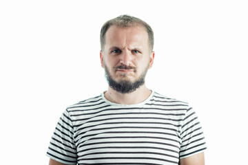 Obraz premium Resentful bearded adult man in a striped T-shirt. 30-35 years old. Isolated on white.