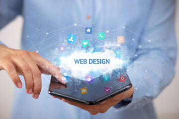 Businessman holding a foldable smartphone with WEB DESIGN inscription, technology concept