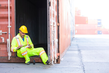 Container hispanic man worker sitting and rest during the day at container warehouse. Marine and carrier insurance concept