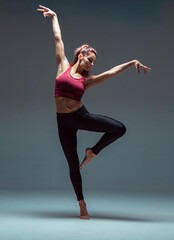 Full-length portrait of a modern female dancer dancing in sportswear.