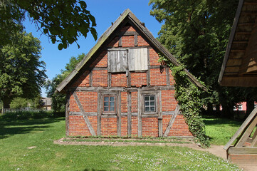 Obraz premium Backstein - Altes Fachwerkhaus im Kirchgarten der St. Johannes-Kirche in Liepe, Lieper Winkel auf der Ostsee-Insel Usedom