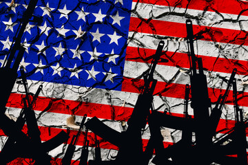 Several automatic rifles raised up on the background of the American flag