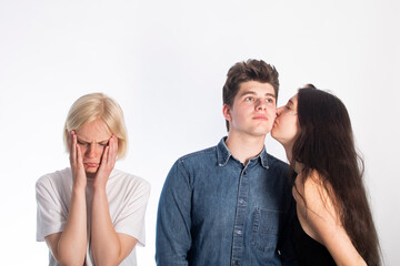the concept of unrequited love. three people on a white background. the couple kisses and the girl is sad