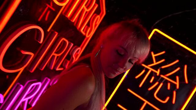 blonde caucasian woman is alluring clients in bordel or peep show nightclub, closeup portrait
