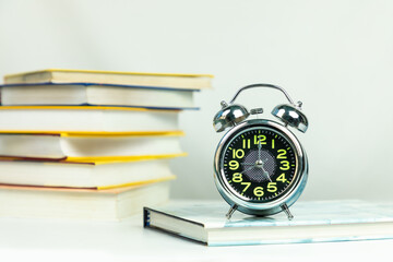 Alarm clock and books, education workspace