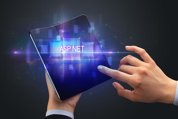 Businessman holding a foldable smartphone with ASP.NET inscription, new technology concept