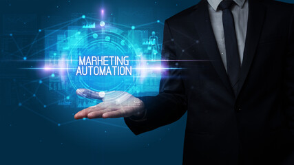 Man hand holding MARKETING AUTOMATION inscription, technology concept