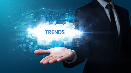 Hand of Businessman holding TRENDS inscription, successful business concept