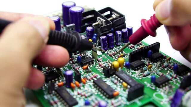 Electronics repair with tester.Repair technician test On an electronic board.Selective focus.