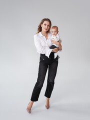 mothercare concept.happy mother with newborn daughter on hands over grey background.motherhood.