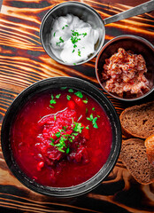 Beetroot soup Traditional Ukrainian or Russian borscht with sour cream in a bowl on wooden table