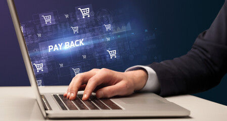 Businessman working on laptop with PAY BACK inscription, online shopping concept