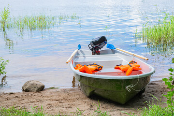Motor boat with orange life jackets on the river bank