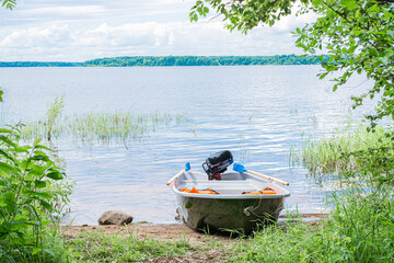 Motor boat with orange life jackets on the river bank