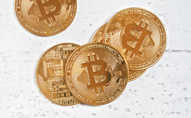 Top down view, golden commemorative btc - bitcoin cryptocurrency - coins scattered on white stone board, closeup detail