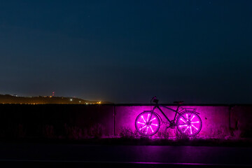 Bicycle with purple lights on the road at night