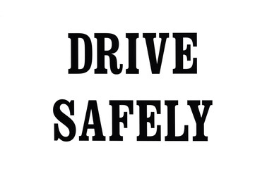 Drive safely sign boldly painted in stencil on a white background. 