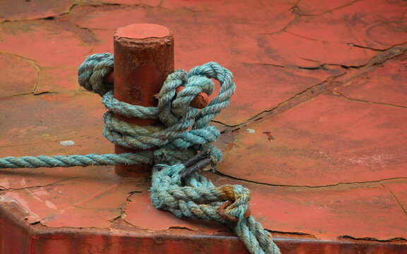 A close up photograph of old rusty paint texture on the side of a fishing boat. 