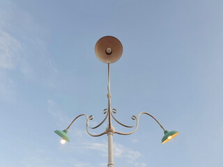 Three green vintage style retro street lamps in blue sky background.There were two lanterns on the...