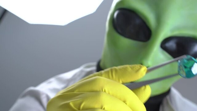 Humanoid robbed someone to conduct experiments on them and torture, holds crystal stone with tweezers. View through eyes of victim.