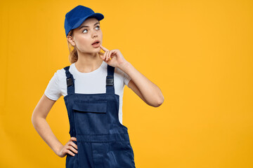 Woman in working uniform blue cap delivering courier service yellow background