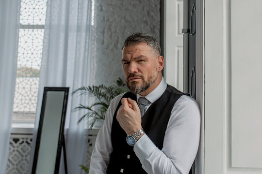 handsome mature courageous stylish scotsman (gay) in kilt by the window. Style, fashion, lifestyle, culture, ethnic concept.