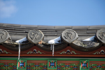icicles which are hanging down from a Korean temple roof
