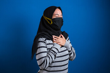 Asian muslim college student girl wearing mask feeling pain in her chest