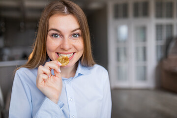 A modern young girl tries gold bitcoin to taste, thinks about crypto currency