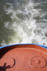 Trail on water surface behind of ship.