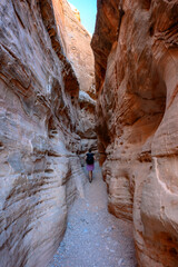 Woman Walks Through Orange Slot Canyon