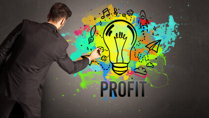 businessman drawing colorful light bulb with PROFIT inscription on textured concrete wall, new business idea concept