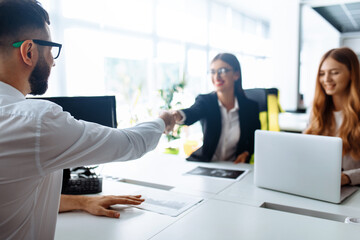 Business people shaking hands, ending a business meeting, after a working day in the office, business concept