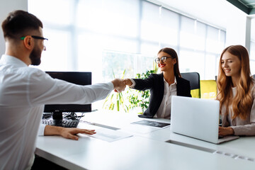 Business people shaking hands, ending a business meeting, after a working day in the office