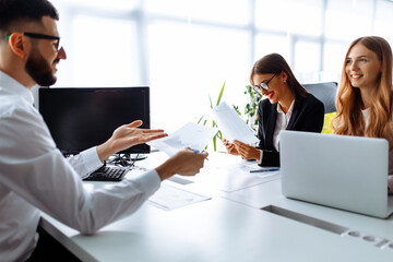 Business partners, colleagues discussing documents and ideas at a meeting in the office